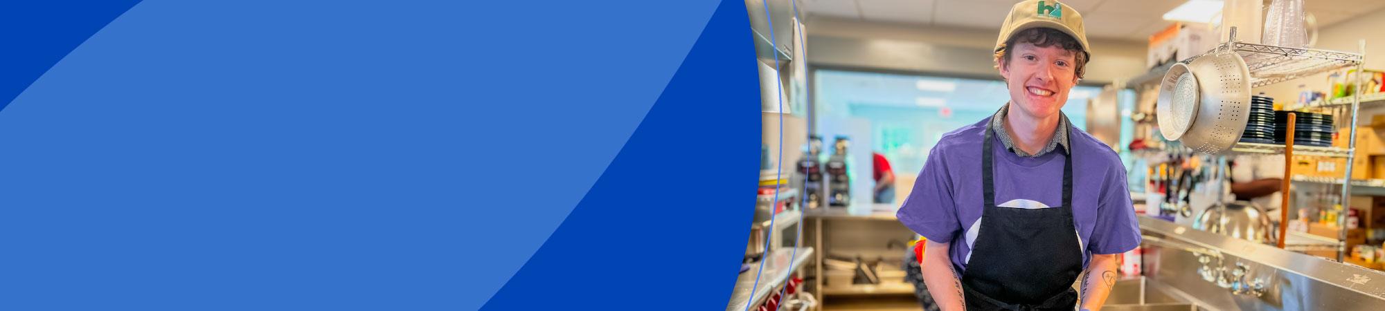 smiling person standing at a sink in a pantry